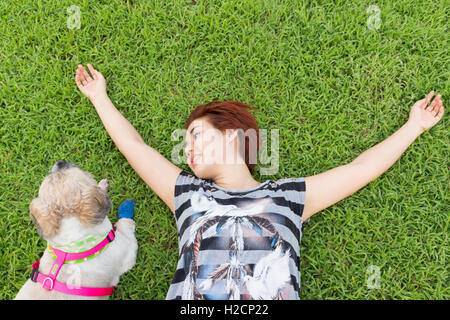 Donna asiatica con il suo cane nel campo Foto Stock