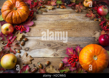Telaio di zucche, mele, ghiande, bacche e foglie di autunno su sfondo di legno. Sfondo di ringraziamento con verdura di stagione Foto Stock