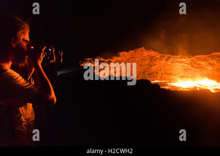 I turisti scattano foto al bordo del cratere Erta Ale, un vulcano a scudo attivo in Etiopia Foto Stock