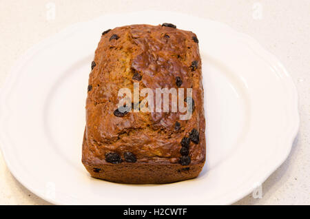 Pane appena sfornato pane alla banana con uvetta su un piatto bianco Foto Stock