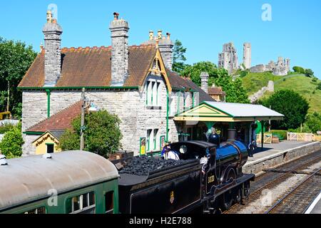 LSWR T9 classe 4-4-0 treno a vapore di entrare nella stazione ferroviaria con il castello al posteriore, Corfe, Dorset, England, Regno Unito, Europa. Foto Stock