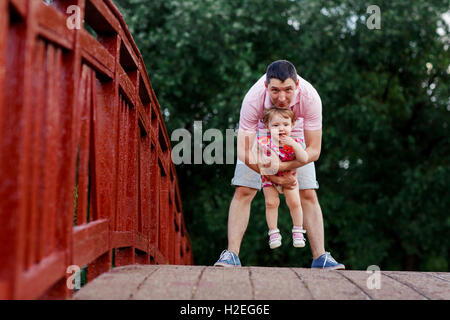 Papà con la sua piccola figlia in piedi sul ponte di legno Foto Stock