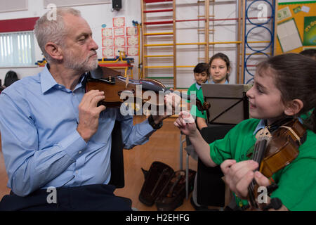 Leader laburista Jeremy Corbyn è dato una lezione di violino da dieci anni di Jessica Kelly durante una visita alla fede la scuola primaria a Liverpool, dove ha incontrato i bambini che partecipano nel progetto di armonia, il quale è supportato dalla Royal Liverpool Philharmonic Orchestra e sta aiutando a scuola i bambini imparano a suonare strumenti musicali. Foto Stock