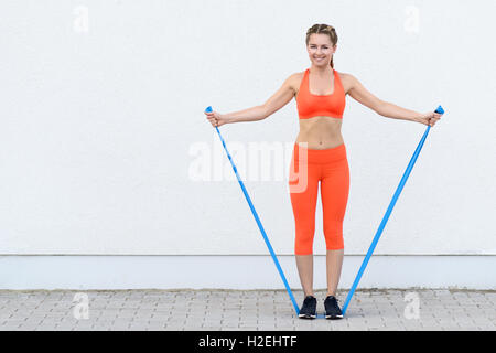 Giovane donna sportivo facendo core Rafforzare esercitazioni utilizzando bande di lattice in una salute e concetto di stile di vita Foto Stock