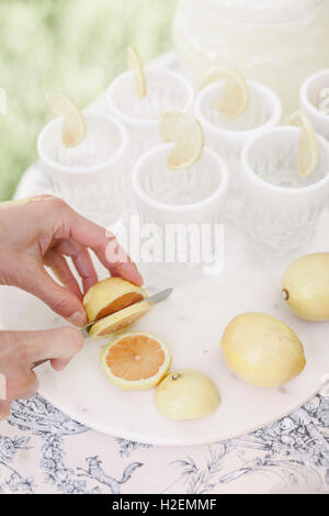 In prossimità di una donna per affettare il limone s per un drink. Foto Stock
