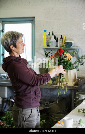 Organici di composizioni floreali. Una donna creando una mano legata al bouquet. Foto Stock