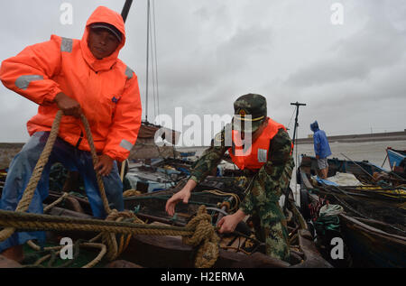 Fuqing, la Cina della provincia del Fujian. Il 27 settembre, 2016. Poliziotti di aiutare i pescatori locali di rafforzare le barche dei pescatori al molo di Dongbi Isola di Longtian township di Fuqing, a sud-est della Cina di provincia del Fujian, Sett. 27, 2016. Megi, xvii typhoon quest'anno, si prevede di spostare a sud del Fujian costa su Mercoledì mattina dopo aver fatto approdo nelle zone costiere orientali di Taiwan martedì pomeriggio. Credito: canzone Weiwei/Xinhua/Alamy Live News Foto Stock