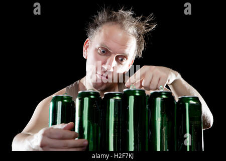 I postumi della sbornia.L'uomo ubriaco ed è un sacco di vuoto di lattine di birra Foto Stock