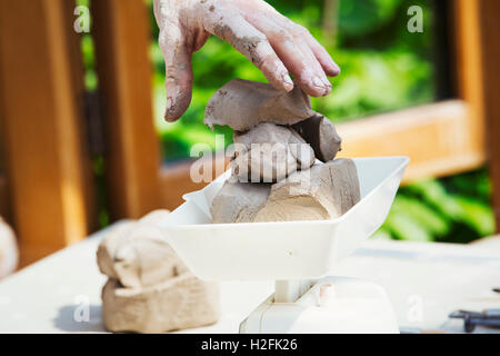 Una donna potter argilla di lavoro su un tornio del vasaio nella sua officina. Foto Stock