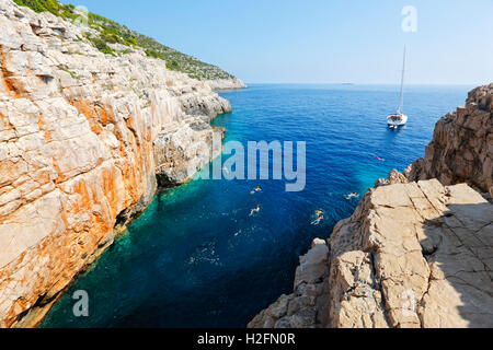 I turisti saltando dal dirupo nel mare su Odisej grotta sul isola di Mljet Foto Stock