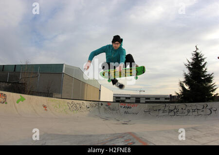 Guidatore di skateboard eseguendo un enorme disossate frontside sulla piramide del skatepark, skateboard, stile vecchia scuola, urban sport Foto Stock