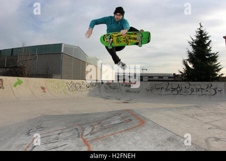 Guidatore di skateboard eseguendo un enorme disossate frontside sulla piramide del skatepark, skateboard, stile vecchia scuola, urban sport Foto Stock