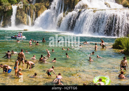 Vistiors nuotare in acqua al di sotto di quella di Skradinski buk cascata nel Parco Nazionale di Krka in Croazia Foto Stock