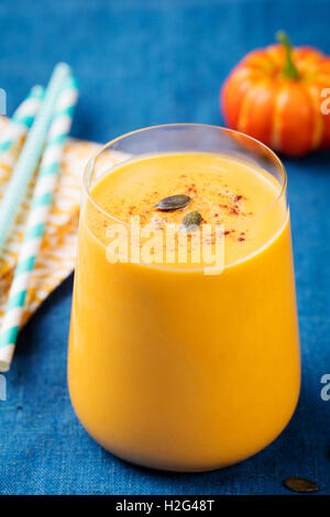 Frullato di zucca con torta di zucca spezie su un blu sullo sfondo di legno Foto Stock