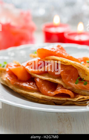 Crepes con salmone affumicato su una piastra bianca per le vacanze Foto Stock