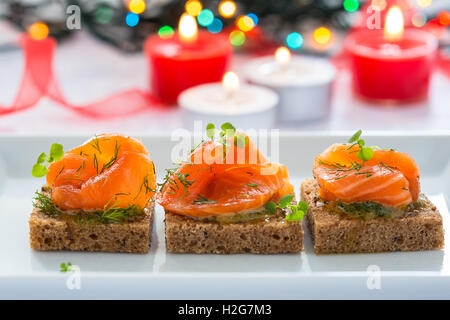 Deliziosi antipasti crostini di pane nero con salmone affumicato per le vacanze Foto Stock