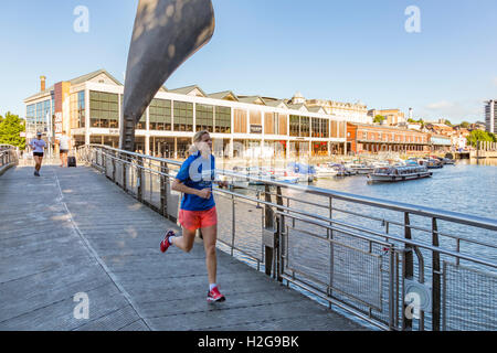 La donna in esecuzione in Bristol City Harbour, Bristol, Avon, England, Regno Unito Foto Stock
