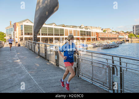 La donna in esecuzione in Bristol City Harbour, Bristol, Avon, England, Regno Unito Foto Stock