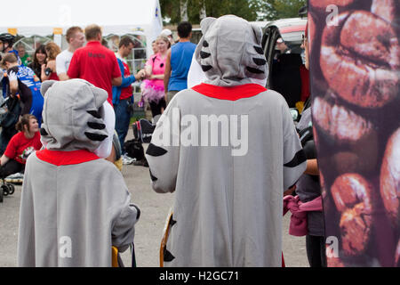 Dietro due persone che indossano onesie animali corrispondenti al circuito di gara Goodwood Motor per la maratona di pattinaggio a rotelle benefica Foto Stock