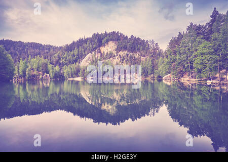 Vintage tonica sereno lago di montagna con la riflessione in acque calme. Foto Stock