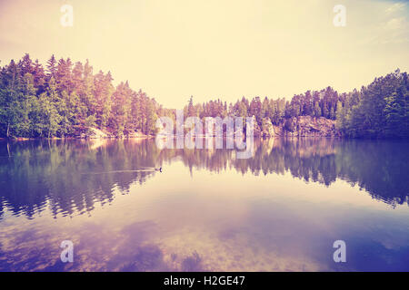 Vintage tonica sereno lago di montagna con la riflessione in acque calme. Foto Stock