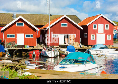 Mollosund, Svezia - 9 Settembre 2016: Travel documentario di piccola marina in città con red boathouses nei pressi di un molo. Una cabina ha Foto Stock