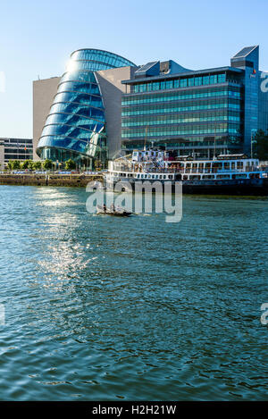 Dragon Boat sul fiume Liffey Dublino Irlanda con centro congressi a Dublino, uffici di pwc e MV Cill Airne ristorante galleggiante Foto Stock