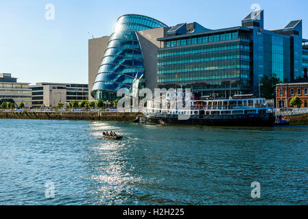 Dragon Boat sul fiume Liffey Dublino Irlanda con centro congressi a Dublino, uffici di pwc e MV Cill Airne ristorante galleggiante Foto Stock