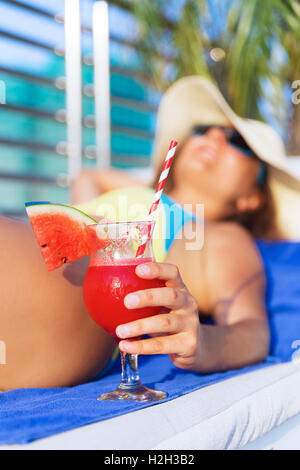 Donna in hat contenente acqua di melone succo fresco drink smoothie cocktail Foto Stock