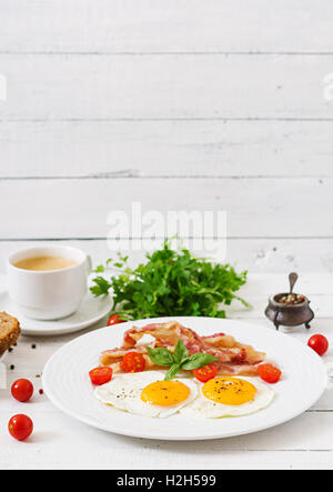 Prima colazione inglese - uovo fritto, pomodori e pancetta. Foto Stock