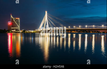 Riga, Lettonia - Luglio 01, 2016: la vista panoramica di Vansu Cable-Stayed Ponte In brillante illuminazione serale oltre il Fiume Daugava Foto Stock