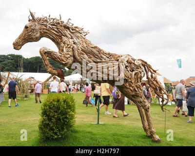 Il salto di legno cavallo scultura da James Doran-Webb, in vendita presso il Tatton Park Flower Show a Knutsford, Cheshire, Regno Unito nel 2016. Foto Stock