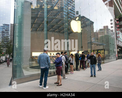 Le persone sono il rivestimento nella parte anteriore di un negozio Apple Store in previsione della sua apertura. Foto Stock