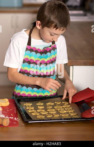 Ragazzo forme di taglio di un collegamento per la pasticceria biscotti Foto Stock