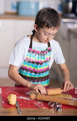 Ragazzo forme di taglio di un collegamento per la pasticceria biscotti Foto Stock