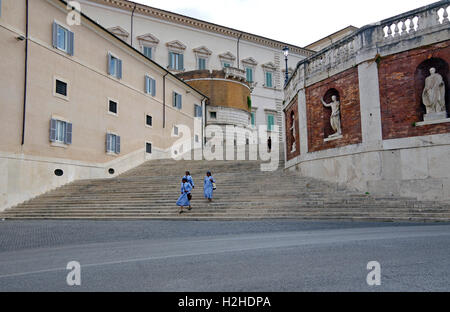 Tre suore africane in blu cielo abitudini e blu scuro veli a piedi giù per una scalinata accanto al Palazzo del Quirinale a Roma. Foto Stock