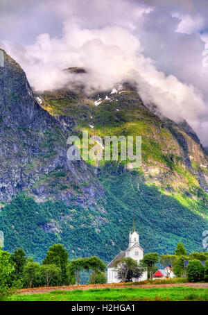 Vista di legno bianco chiesa Oppstryn e montagne in Sogn og Fjordane county, Norvegia Foto Stock