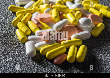 Pila di diverse pillole colorate Foto Stock