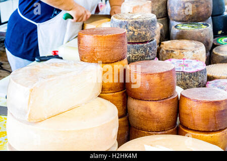 La tradizione locale formaggi sardi visualizzata su un mercato settimanale in stallo, Baia Sardinia, Gallura Sardegna, Italia. Foto Stock