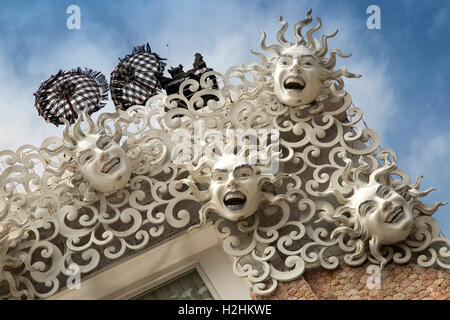 Indonesia Bali Kuta, Jalan Pantai Kuta, Angel's Hotel, ridendo volti scultura lungo il bordo del tetto Foto Stock