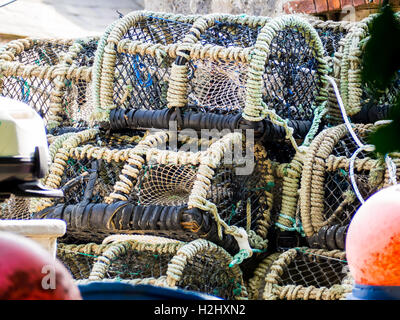 Pescato granchi cestelli impilati con altri arnesi da pesca. Foto Stock