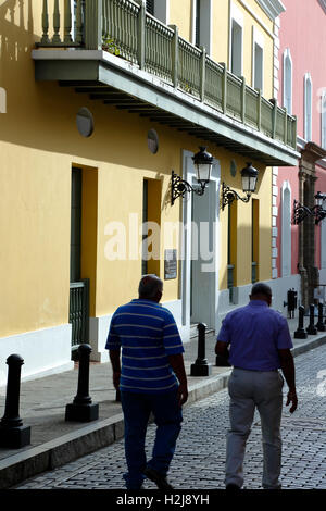 Uomini a piedi da colorate stile coloniale spagnolo facciate, Fortaleza Street, Old San Juan, Puerto Rico Foto Stock