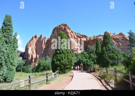 La gente di escursioni presso il Giardino degli dèi Park in mezzo alle formazioni di arenaria e alberi sempreverdi. Foto Stock