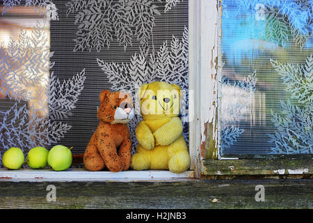 Coppia giocattoli imbottiti sul davanzale della finestra della vecchia casa rurale in estate Foto Stock