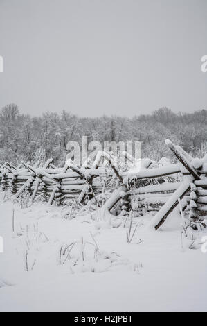 Fence coperta da neve vecchia ferrovia spaccata in legno, New Jersey, USA, Monmouth Battlefield state Park, Freehold, New Jersey, inverno vintage neve scena fattoria nevoso Foto Stock