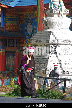 Un anziano tibetano lady va circa la sua routine mattutina in Jiuzhaigou Parco Nazionale, Cina. Foto Stock