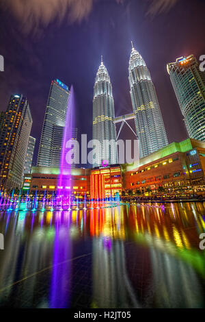 Suria KLCC Shopping Mall e le Torri Gemelle Petronas notte acqua colorata mostra. Foto Stock