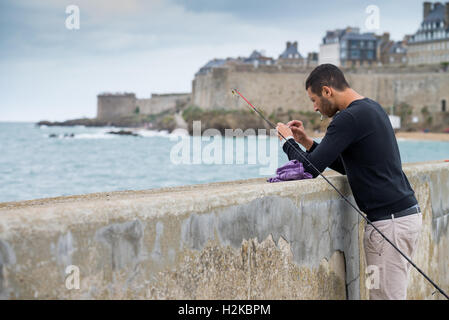 Persone di pesca su 'Mole des Noirs' in St Malo Bretagna Francia Foto Stock