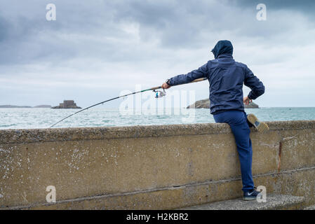 Persone di pesca su 'Mole des Noirs' in St Malo Bretagna Francia Foto Stock