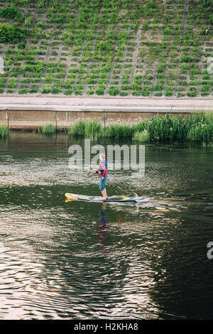 Vilnius Lituania - Luglio 08, 2016: Giovane pratica Stand Up Paddling SUP o Standup Paddle imbarco sul fiume Neris Foto Stock